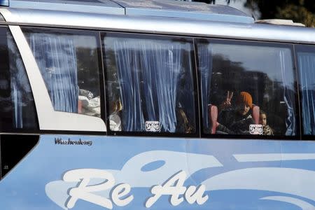 A man gestures as he looks out of the window in a bus leaving district of Waer during a truce between the government and rebels, in Homs December 9, 2015. REUTERS/Omar Sanadiki