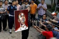 Todung Mulya Lubis, lawyer for two Australians facing the death penalty, Myuran Sukumaran and Andrew Chan, holds a self-portrait painted by Sukumaran at Wijayapura port in Cilacap, Indonesia, April 27, 2015. REUTERS/Beawiharta