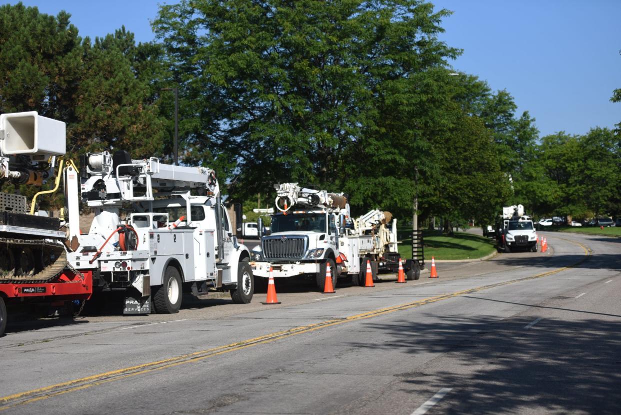 A convoy of utility trucks from a Kentucky line company waiting to deploy, Monday, Aug. 28, 2023, outside the Comfort Inn Okemos