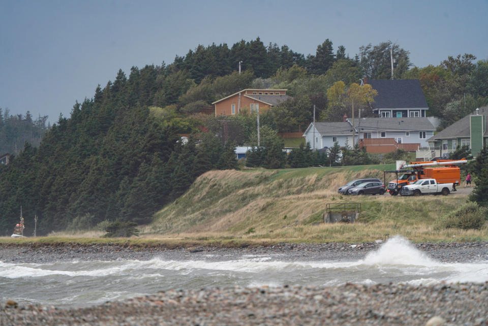 <p>Waves crash ashore as vehicles watch during the arrival of Hurricane Fiona, later downgraded to a post-tropical storm, in Stephenville, Nfld. on Sept. 24, 2022. (REUTERS/John Morris)</p> 
