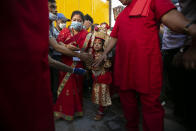 Nepal's revered living god Bhairabh walks towards a chariot during the annual Indra Jatra festival in Kathmandu, Nepal, Sunday, Sept. 19, 2021. The feast of Indra Jatra marks the return of the festival season in the Himalayan nation two years after it was scaled down because the pandemic. (AP Photo/Niranjan Shrestha)