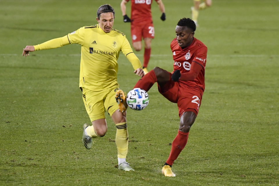 Toronto FC's Richie Laryea, right, controls the ball as Nashville SC's Alex Muyl defends during the first half of an MLS soccer playoff match Tuesday, Nov. 24, 2020, in East Hartford, Conn. (AP Photo/Jessica Hill)