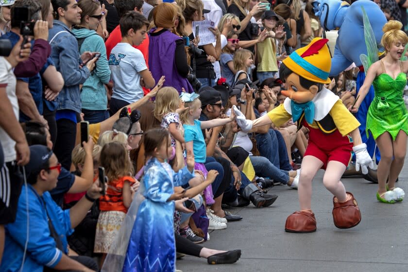 ANAHEIM, CALIF. -- THURSDAY, FEBRUARY 27, 2020: Pinocchio and Tinker Bell greet Disneyland guests in the new daytime parade titled "Magic Happens" of more than 90 dancers on Main Street U.S.A. on Thursday, Feb. 27, 2020 in Anaheim. Disneyland gave the media and Disneyland guests a sneak peak of the parade that will begin running for the general public Friday, Feb. 28. (Allen J. Schaben / Los Angeles Times)