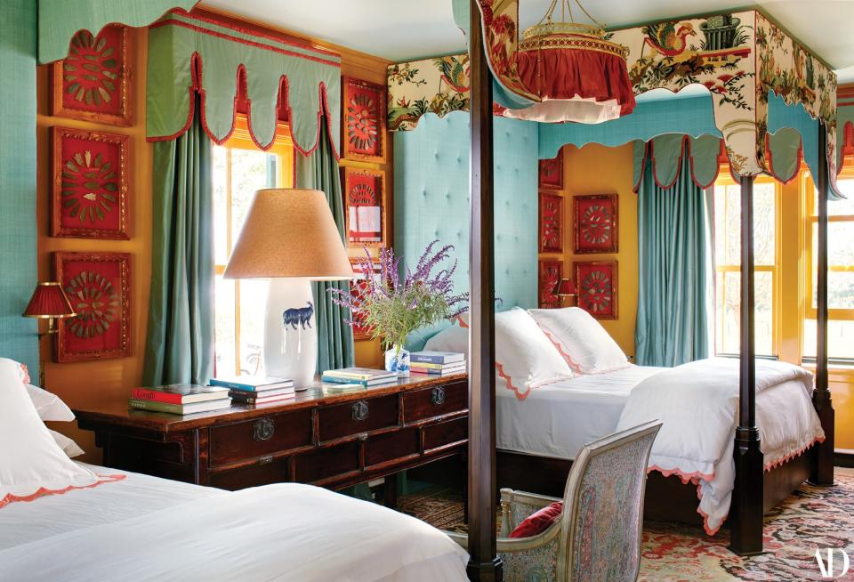 Canopies of a Brunschwig & Fils linen print and Old World Weavers silk shelter the beds in a guest bedroom lined with framed arrowheads. Biscuit Home bedding.