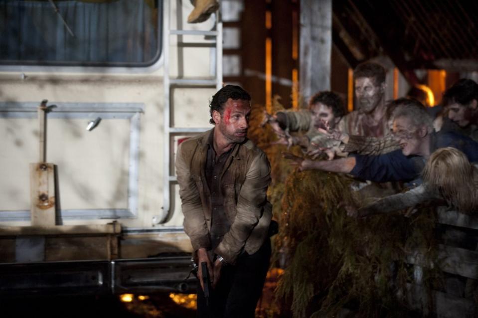 Rick runs from an RV to escape a herd of walkers in the walking dead 