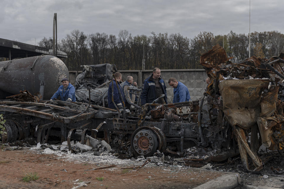 Workers inspect a fuel depot hit by Russian missile in the town of Kalynivka, about 30 kilometers (18 miles) southwest of Kyiv, Ukraine, Thursday, Oct. 27, 2022. Environmental damage caused by Ukraine’s war is mounting in the 8-month-old conflict, and experts warn of long-term health consequences for the population. (AP Photo/Andrew Kravchenko)