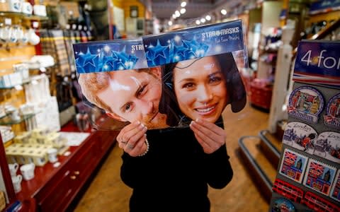 A shopkeeper holds wedding souvenirs in a gift shop in Windsor - Credit: Tolga Akmen