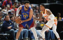 Denver Nuggets guard Jamal Murray (27) looks to pass the ball as Atlanta Hawks guard Dejounte Murray defends in the first half of an NBA basketball game Saturday, April 6, 2024, in Denver. (AP Photo/David Zalubowski)