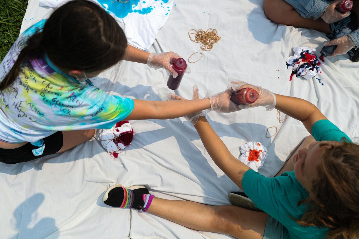 Campers swap tie dye colors during an art-making session at summer camp.