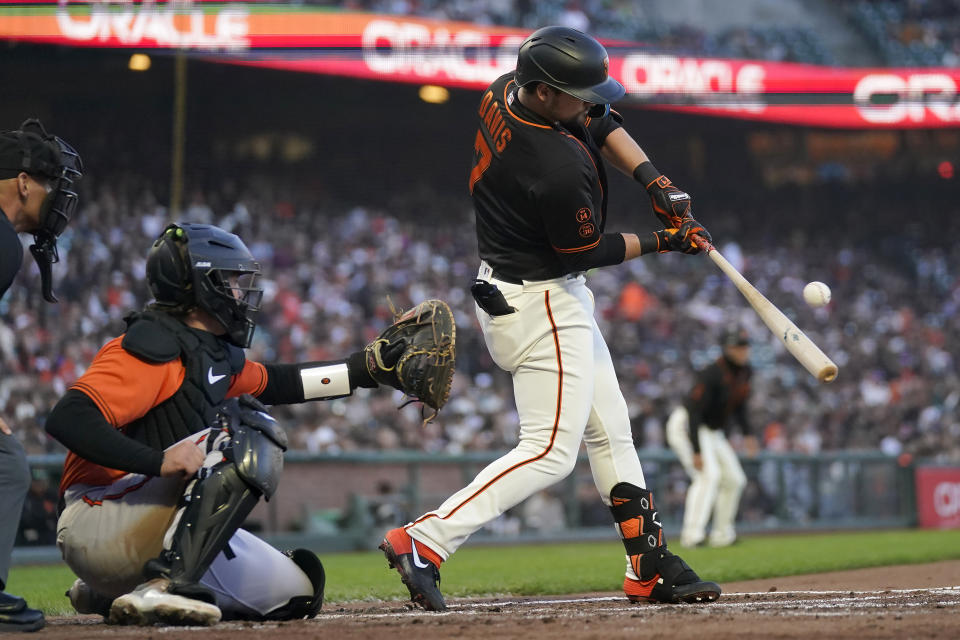 San Francisco Giants' J.D. Davis hits an RBI single in front of Baltimore Orioles catcher Adley Rutschman during the third inning of a baseball game in San Francisco, Saturday, June 3, 2023. (AP Photo/Jeff Chiu)