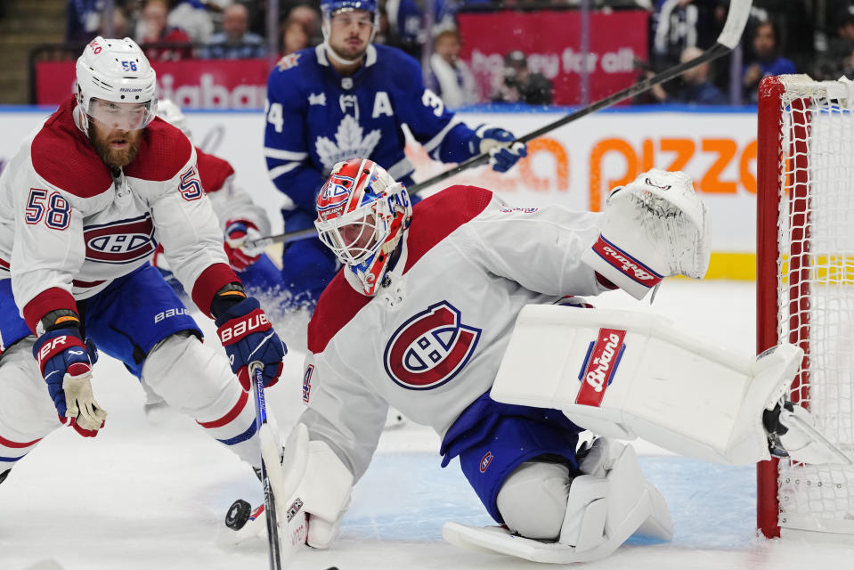 Montreal Canadiens goaltender Jake Allen (34) makes a save against the Toronto Maple Leafs as David Savard (58) defends during the second period of an NHL hockey game Wednesday, Oct. 11, 2023, in Toronto. (Frank Gunn/The Canadian Press via AP)