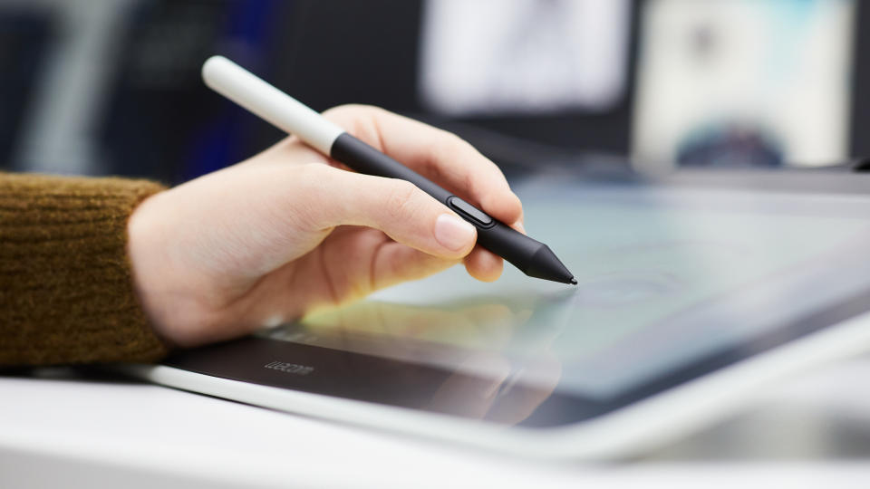 Close-up of hand using a pen using one of the best Wacom tablets