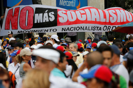 Demonstrators hold a placard reads: 'No more Socialism' while rallying against Venezuela's President Nicolas Maduro in Caracas, Venezuela May 1, 2017. REUTERS/Carlos Garcia Rawlins