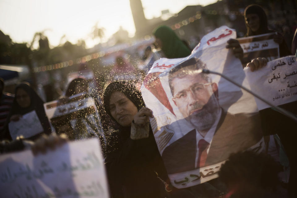A supporter of Egypt's ousted President Mohammed Morsi sprays water on an Egyptian woman during a protest near Cairo University in Giza, Egypt, Thursday, August, 1, 2013. (AP Photo/Manu Brabo)