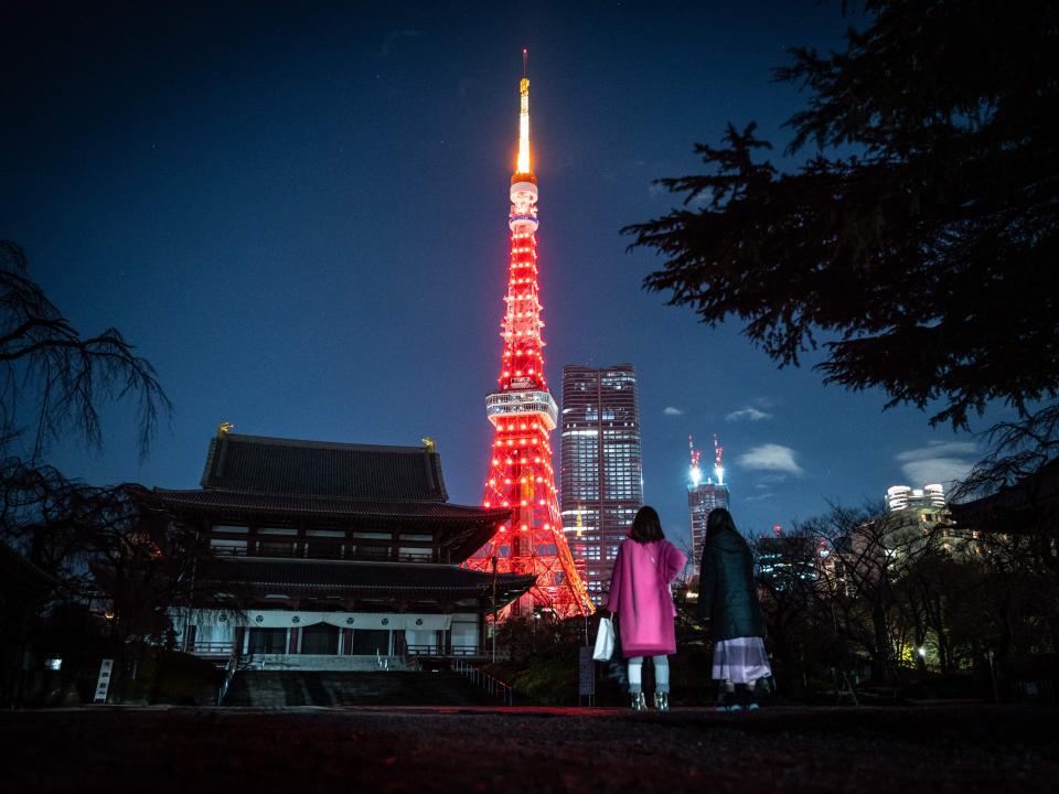 People visit Zojoji temple as Tokyo Tower is lit in red to celebrate the Chinese Lunar New Year in Tokyo on January 21, 2023.