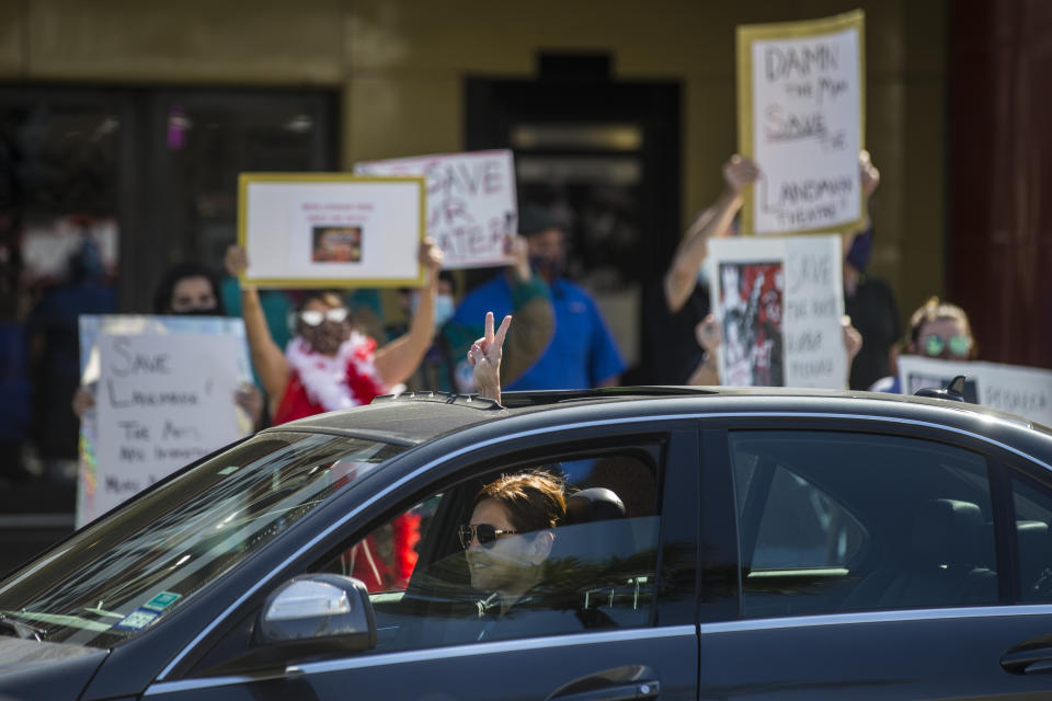 A driver passing by gives their support to fans and patrons of the Landmark River Oaks Theatre demonstrating against the potential closure of the historic movie theater Sunday, March 7, 2021, in Houston. The historic theater that director Richard Linklater called his “film school” and that for decades was the place to catch hard-to-find independent and foreign films has closed for good. Like many U.S. movie theaters and other businesses, the River Oaks Theatre was a victim of the coronavirus pandemic. ( Brett Coomer/Houston Chronicle via AP)