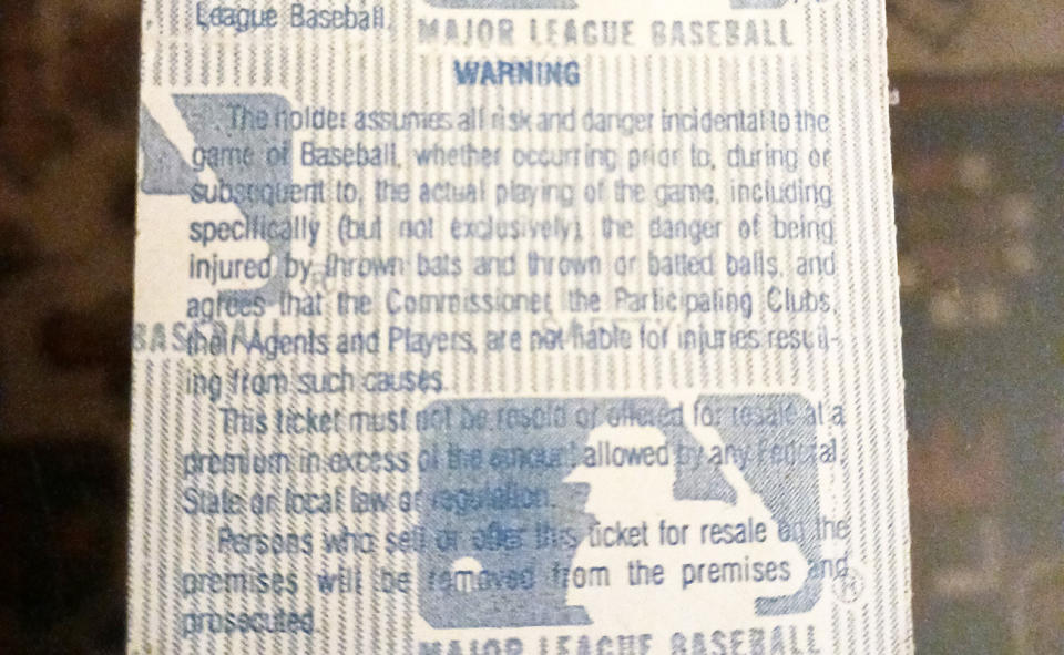 An MLB ticket, pictured here with a warning about foul balls.