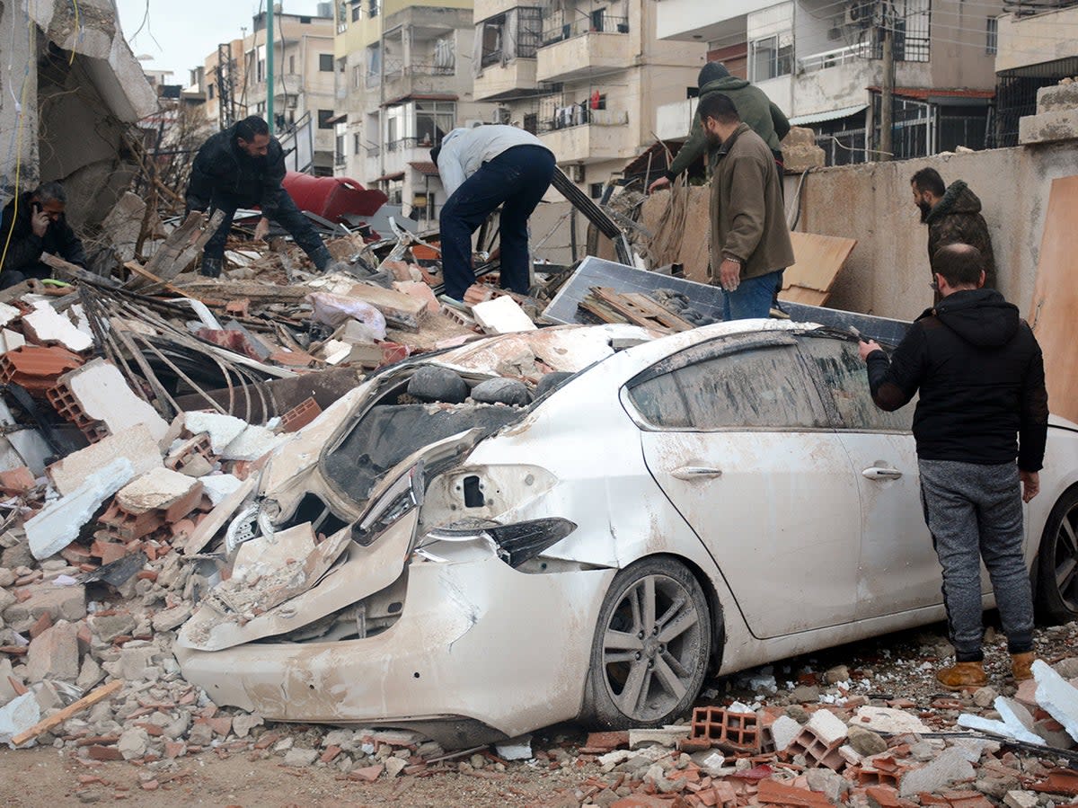Rescuers search for survivors at the site of a collapsed building, following an earthquake, in Latakia, Syria (Reuters)