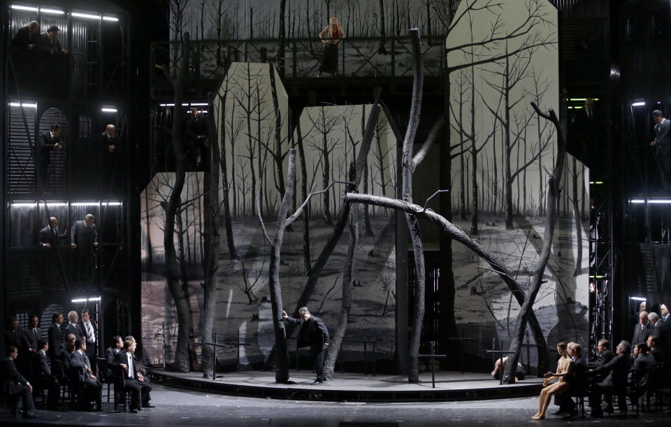 In this picture taken Friday, June 21, 2013, Kwangchul Youn in the role of Ferrando, center, sings during a dress rehearsal for the opera "Il Trovatore" by Giuseppe Verdi in the Bavarian State Opera House in Munich, southern Germany. This wild new production by Olivier Py opened the company's annual Munich Opera Festival. It's a non-stop barrage of nightmarish images mixing styles and periods that assault the audience at lightning speed on a multi-tiered revolving set. (AP Photo/Matthias Schrader)