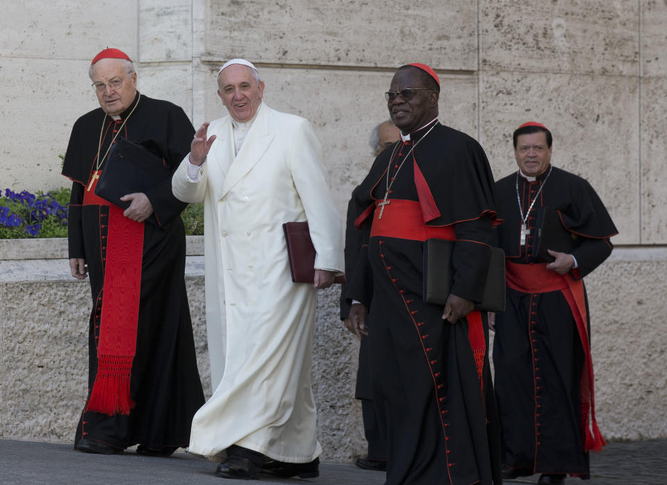 Pope Francis, flanked by cardinals Angelo Sodano, left, Laurent Monsengwo Pasinya, second from right, and Norberto Rivera Carrera, arrives to open the morning session of an extraordinary consistory in the Synod hall at the Vatican City, Friday, Feb. 21, 2014. Pope Francis is leading a two-day meeting urging his cardinals to find "intelligent, courageous" ways to help families under threat today without delving into case-by-case options to get around Catholic doctrine. He said the church must find ways to help families with pastoral care that is "full of love."(AP Photo/Alessandra Tarantino)