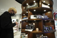 Customer Kenta Yamazaki, a 24-year-old hairdresser, looks at beauty products at @cosme TOKYO, a store selling a selection of cosmetics and makeup products including men's cosmetic, in Tokyo's Harajuku district Tuesday, Feb. 9, 2021. The coronavirus pandemic has been pushing businesses to the edge in Japan, but some in the men's beauty industry have seen an unexpected expansion in their customer base. Japanese businessmen in their 40s, 50s and 60s who had little interest in cosmetics before the pandemic are now buying makeup. (AP Photo/Eugene Hoshiko)