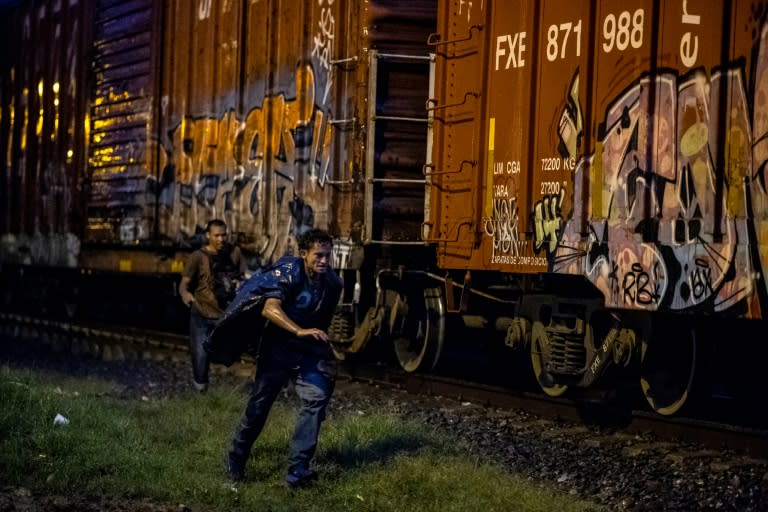 A migrant runs next to the freight train heading toward the US border