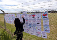 A woman places drawings with messages in support of the 44 crew members of the missing at sea ARA San Juan submarine on a fence at an Argentine naval base in Mar del Plata, Argentina November 22, 2017. REUTERS/Marcos Brindicci