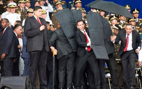 Security agents surround Nicolas Maduro after explosion heard - Credit: Xinhua via AP