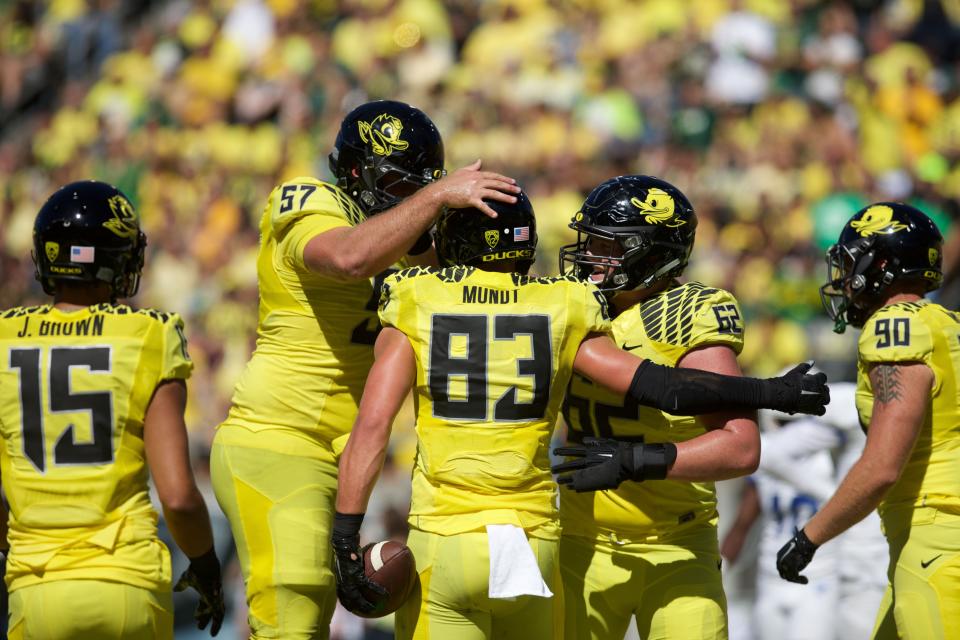 Offensive lineman Doug Brenner (57) celebrates a touchdown with tight end Johnny Mundt (83) in 2015.