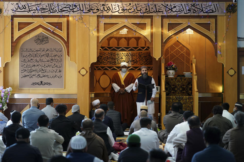 Hammad Khan, top right, the Chair of the Executive Committee at Manchester Central Mosque addresses the congregants partly about the new coronavirus safety measures, in Manchester, northern England, after having their temperatures checked at the entrance to try stop the spread of coronavirus, as Muslims worldwide mark the start of the Eid al-Adha holiday, Friday, July 31, 2020. The British government on Thursday night announced new rules on gatherings in some parts of Northern England, including Manchester, that people there should not mix with other households in private homes or gardens in response to an increase trend in the number of cases of coronavirus cases per 100,000 people. (AP Photo/Jon Super)