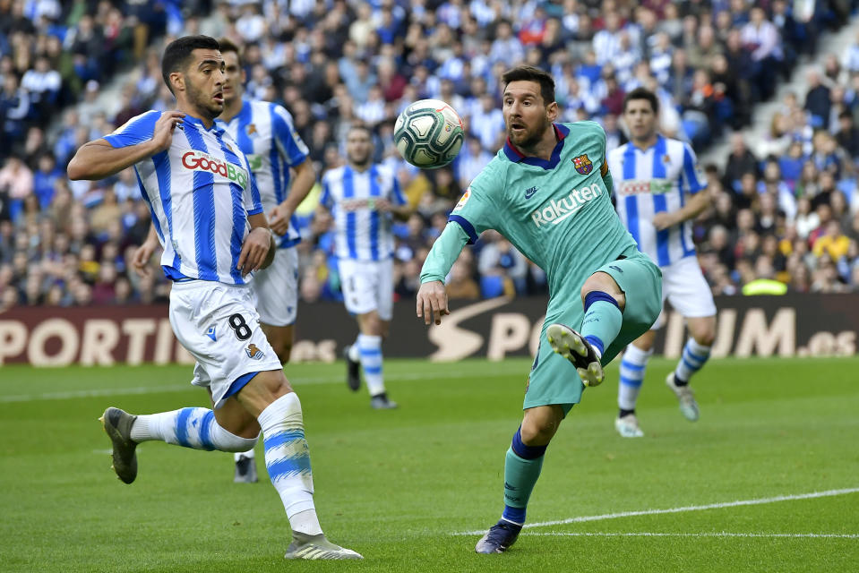 Lionel Messi del Barcelona patea el balón frente a Mikel Merino de la Real Sociedad en el partido por la Liga española en San Sebastián, el sábado 14 de diciembre de 2019. (AP Foto/Alvaro Barrientos)