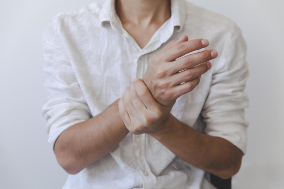 A selective focus shot of a male holding his painful wrist