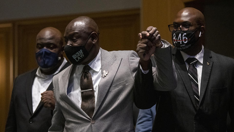 Attorney Ben Crump (C) holds up the hand of Philonise Floyd (R), and is joined by Rodney Floyd (L) as they enter a press conference at the Minneapolis Convention Center on March 12, 2021 in Minneapolis, Minnesota. (Stephen Maturen/Getty Images)