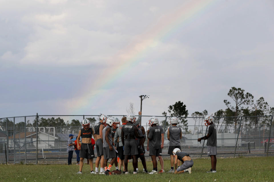 A rainbow appears as Mosley High football players practice outside their heavily damaged school, in the aftermath of Hurricane Michael in Lynn Haven, Fla., Friday, Oct. 19, 2018. (AP Photo/Gerald Herbert)