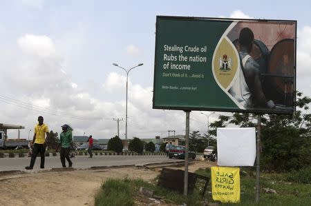 A billboard erected as part of a campaign against crude oil theft is seen alongside a road in Yenagoa, the capital of Nigeria's oil state of Bayelsa November 28, 2012. REUTERS/Akintunde Akinleye/Files