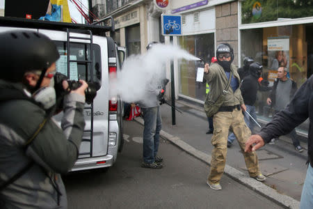 A plain-clothes policeman uses tear gas during clashes at a demonstration against the government's labour reforms in Nantes, France, September 21, 2017. REUTERS/Stephane Mahe