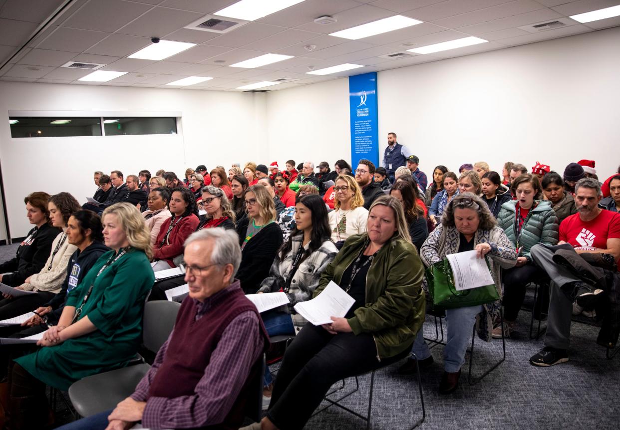 Teachers and members of the public listen as the  Salem-Keizer School Board gives a report on proposed budget cuts during a school board meeting on Tuesday.