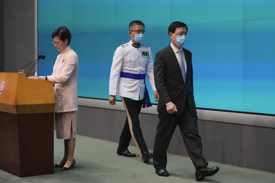 Hong Kong's Chief Executive Carrie Lam, left, speaks as Chief Secretary John Lee, right, and Commissioner of Police Raymond Siu leave a news conference in Hong Kong, Friday, June 25, 2021. China on Friday promoted Hong Kong's top security official to the territory's No. 2 spot as Beijing continues to clamp down on free speech and political opposition. (AP Photo/Kin Cheung)