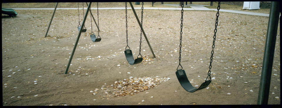 A view of a swing set at a lonely playground in Bisbee, Ariz., Oct. 26, 2021. Bisbee was home to Paul and Leizza Adams, and their six children, before Paul and Leizza were charged with child sexual abuse. (AP Photo/Dario Lopez-Mills)