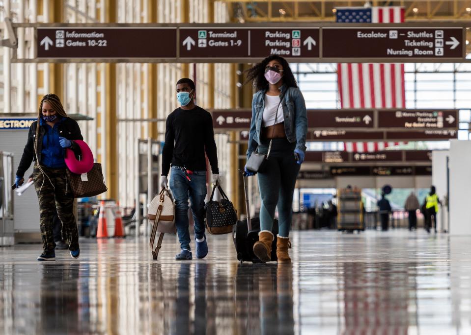Passengers walk through a mostly empty Ronald Reagan Washington National Airport in Arlington, Virginia, on May 12, 2020. - The airline industry has been hit hard by the COVID-19 pandemic, with the number of people flying having decreased by more than 90 percent since the beginning of March. (Photo by ANDREW CABALLERO-REYNOLDS / AFP) (Photo by ANDREW CABALLERO-REYNOLDS/AFP via Getty Images)