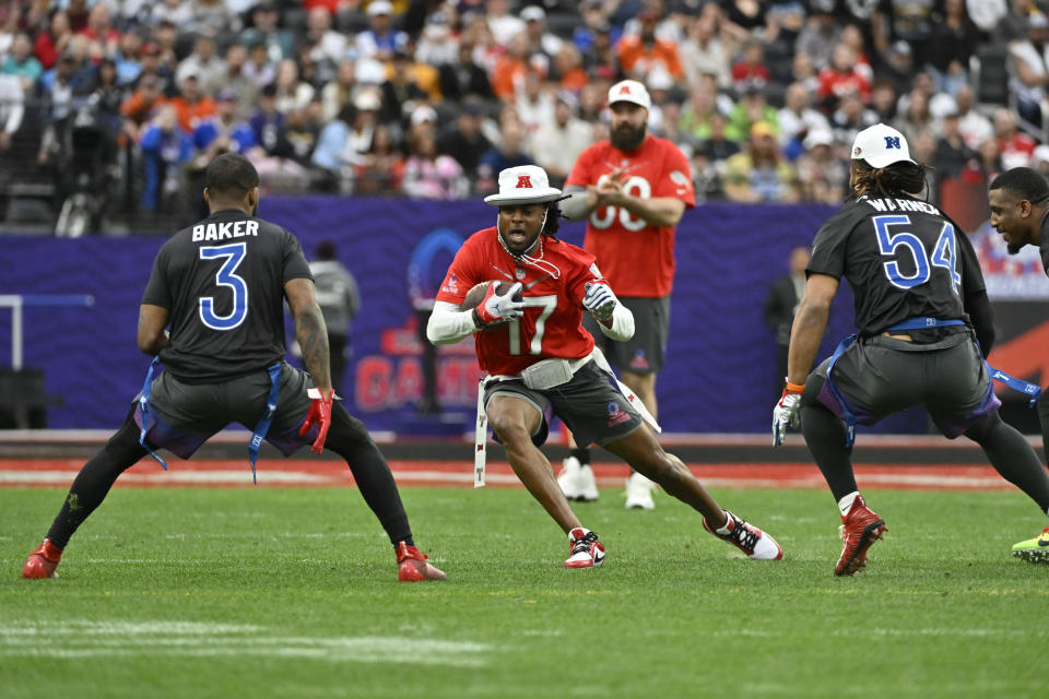 El wide receiver Davante Adams (17), de los Raiders de Las Vegas, corre con el balón por la AFC ante la marcación delsafety Budda Baker (3), de los Cardinals de Arizona, y el linebacker Fred Warner (54), de los 49ers de San Francisco, por la NFC, en partido de fútbol americano bandera del reformateado Pro Bowl de la NFL, el domingo 5 de febrero de 2023, en Las Vegas. (AP Foto/David Becker)