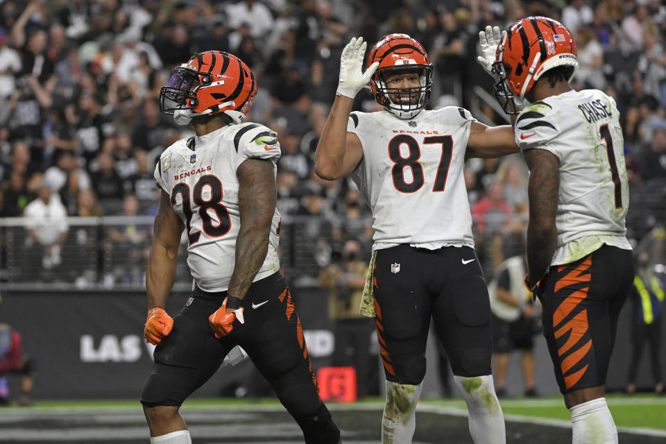 Cincinnati Bengals wide receiver Ja'Marr Chase (1) and tight end C.J. Uzomah (87) celebrate after running back Joe Mixon (28) scored a touchdown against the Las Vegas Raiders during the second half of an NFL football game, Sunday, Nov. 21, 2021, in Las Vegas. (AP Photo/David Becker)