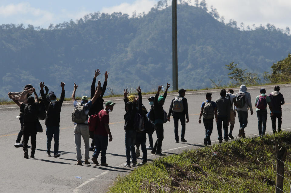 Migrants walk on the road on their way North near Agua Caliente, close to the border with Guatemala, Thursday, Dec. 10, 2020. Honduran security forces stationed on the highway a few kilometers before Agua Caliente, asked the migrants for their passports or identity cards and proof of a COVID-19 test, and if they did not produce those documents they would not be allowed to move on. (AP Photo/Delmer Martinez)