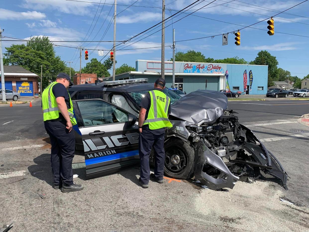 Firefighters from the Marion Fire Department examine a Marion Police Department vehicle that was involved in a collision with a fire department ambulance on Monday, May 29, 2023, at the intersection of North Main and Fairground streets in Marion. Police Officer Daniel Ice suffered serious injuries in the crash and was transported to a Columbus hospital. Firefighter Nicholas Hunley suffered a minor ankle injury and Firefighter Jacob Fohl was not injured.