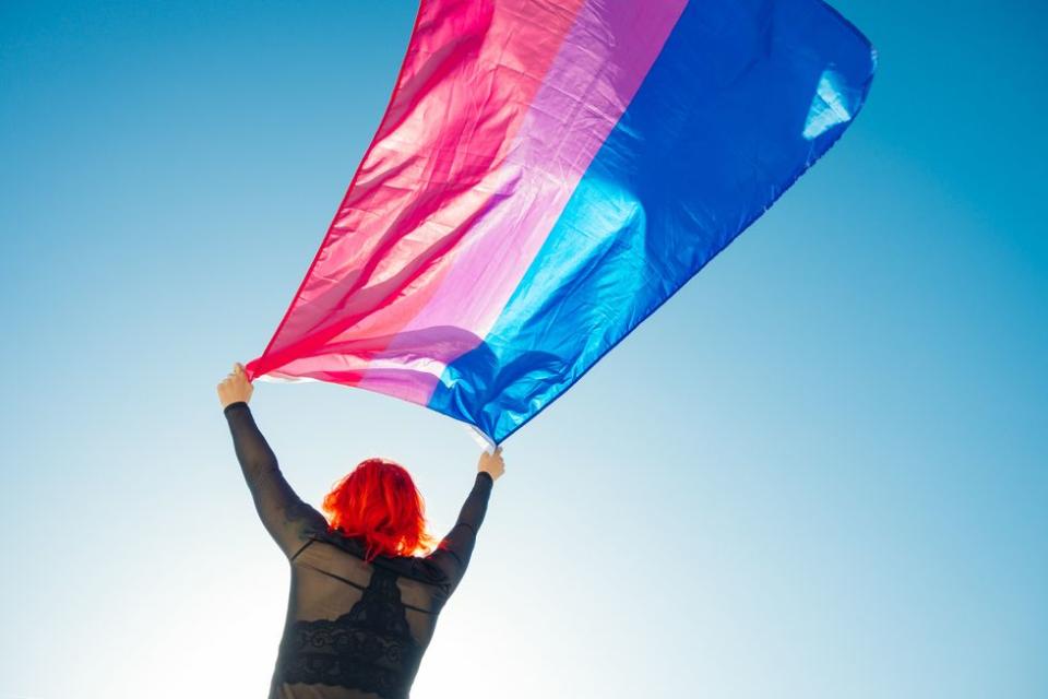 woman holding a bisexual flag