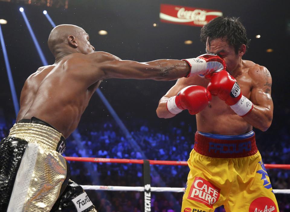 Floyd Mayweather, Jr. of the U.S. (L) lands a right against Manny Pacquiao of the Philippines in the sixth round during their welterweight WBO, WBC and WBA (Super) title fight in Las Vegas, Nevada, May 2, 2015. REUTERS/Steve Marcus