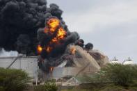 Los bomberos intentan extinguir el incendio en tres tanques de la refinería de petróleo de la estatal PDVSA de Amuay, en Punto Fijo, Venezuela, el lunes 27 de agosto. (AFP | Héctor Silva)