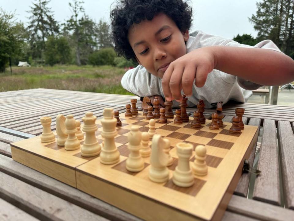 Langston Garcia-Blake, 9, of Portland plays chess at Snow Peak’s Campfield Long Beach lounge area.