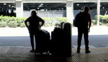 A couple waits for transportation at Terminal 5 at LAX on Wednesday, Aug. 30, 2023, in Los Angeles. With Labor Day weekend just days away, airports and roadways are expected to be busy as tens of thousands of Southern Californians travel out of town. (Dean Musgrove/The Orange County Register via AP)