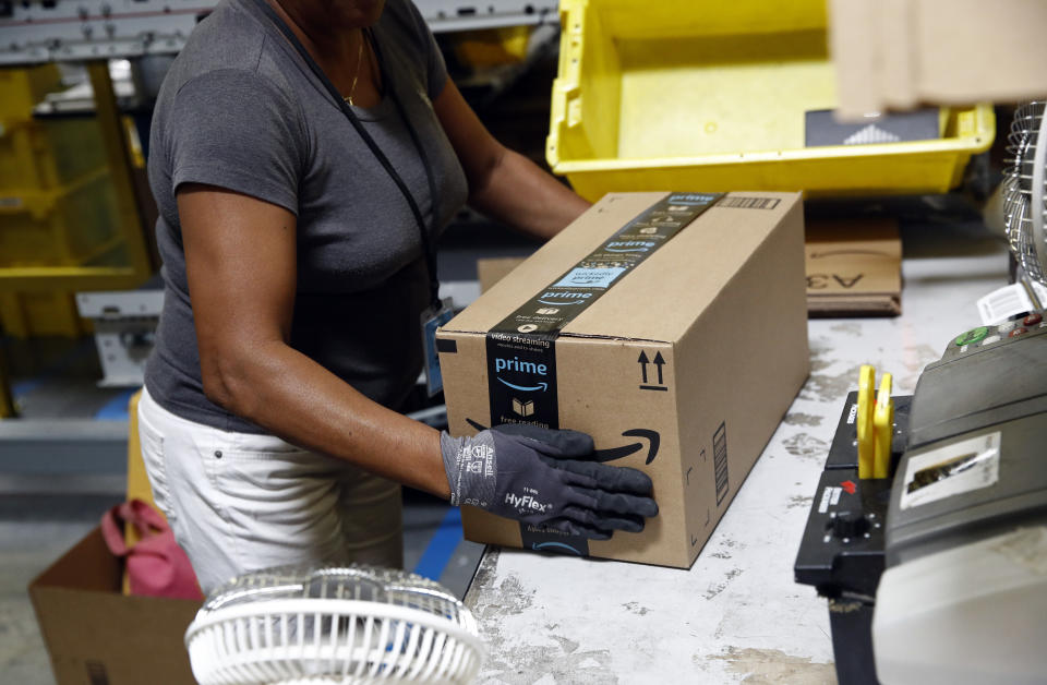 Myrtice Harris applies tape to a package before shipment at an Amazon fulfillment center in Baltimore. (AP Photo/Patrick Semansky, File)